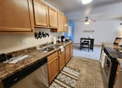 Thumbnail 3 of 28 - A kitchen with wooden cabinets and a stainless steel dishwasher.