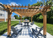 Thumbnail 23 of 29 - A wooden pavilion with a table and chairs and grill