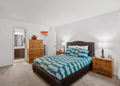 Thumbnail 12 of 29 - a bedroom with a bed and dressers and a bathroom