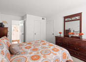 Thumbnail 10 of 29 - a bedroom with a bed and a dresser and a mirror