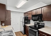 Thumbnail 2 of 29 - a kitchen with black appliances and wooden cabinets