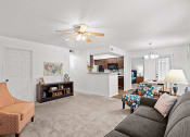 Thumbnail 5 of 29 - a living room with a couch and a ceiling fan