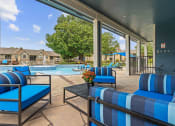 Thumbnail 25 of 29 - a balcony with blue chairs and a view of a yard and trees