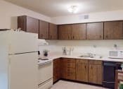 Thumbnail 7 of 10 - apartment kitchen with white appliances and wooden cabinets