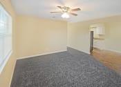 Thumbnail 12 of 30 - A room with a ceiling fan and carpeted floor.
