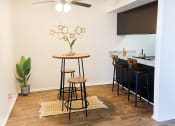 Thumbnail 4 of 16 - a living room with a bar with stools and a ceiling fan