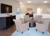 Thumbnail 9 of 16 - a living room with chairs and a table and a tv