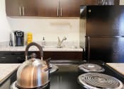 Thumbnail 6 of 16 - a kitchen with a stove and a kettle on the stove