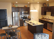 Thumbnail 1 of 12 - apartment kitchen with stainless steel appliances and a large island with a breakfast bar