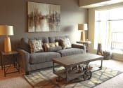 Thumbnail 2 of 12 - a living room with a gray couch and a coffee table