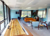 Thumbnail 6 of 10 - a bowling alley in a living room with furniture and windows