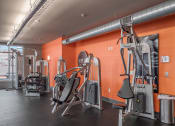 Thumbnail 20 of 34 - a gym with weights machines and a poster on the wall