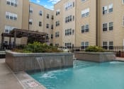 Thumbnail 29 of 34 - a pool with a waterfall in front of a building
