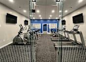 Thumbnail 15 of 26 - A gym with treadmills and exercise bikes.