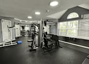 Thumbnail 17 of 26 - A black and white photo of a gym with various exercise equipment.