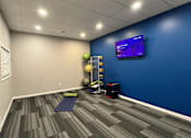 Thumbnail 18 of 26 - A room with a blue wall and a television mounted on it.