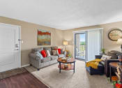 Thumbnail 5 of 31 - a living room with a couch and a chair and a door to a balcony