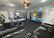 Thumbnail 21 of 31 - A gym with a variety of equipment including treadmills, weights, and exercise balls.