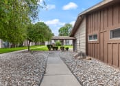 Thumbnail 22 of 23 - a walkway leading to a house with gravel and trees