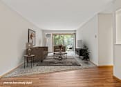 Thumbnail 1 of 23 - A living room with a brown couch and a rug.