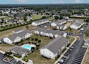 Thumbnail 29 of 29 - A large white building with a pool in the middle of a parking lot.