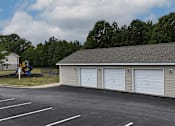 Thumbnail 20 of 29 - A parking lot with a playground and a building with three garage doors.