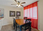 Thumbnail 8 of 27 - a dining room with a table and chairs and a ceiling fan