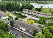 Thumbnail 34 of 35 - A bird's eye view of a residential area with a lake in the background.