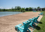 Thumbnail 17 of 26 - a row of blue beach chairs sitting on the sand near the water