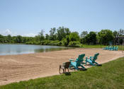 Thumbnail 19 of 26 - a group of chairs sitting on a beach next to a lake