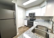 Thumbnail 3 of 26 - Spacious kitchen with granite countertops 