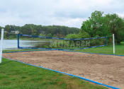 Thumbnail 12 of 26 - a volleyball court on a wandy beach next to a lake