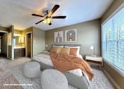 Thumbnail 9 of 26 - A bedroom with a bed, a ceiling fan, and a nightstand.