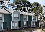 Thumbnail 21 of 26 - A row of houses with green siding and white trim.