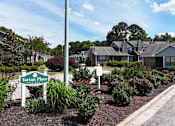 Thumbnail 24 of 26 - A sign for Tartan Place Apartments is in front of a well-manicured garden.