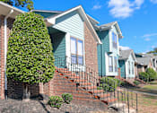 Thumbnail 19 of 26 - An apartment building with a blue siding  and brick details
