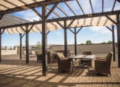 Thumbnail 16 of 23 - a patio with a wooden table and chairs