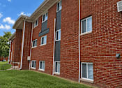 Thumbnail 9 of 9 - A red brick building with a green lawn in front.