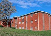 Thumbnail 7 of 7 - A red brick building with a tree in front of it.