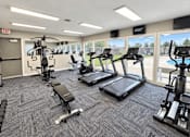Thumbnail 1 of 9 - A gym with treadmills, weights, and exercise equipment.