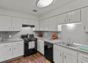 Thumbnail 13 of 31 - a kitchen with white cabinets and black appliances and a sink