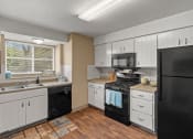 Thumbnail 1 of 31 - a kitchen with black appliances and white cabinets