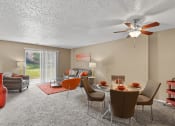 Thumbnail 10 of 31 - a living room with a table and chairs and a ceiling fan
