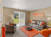 Thumbnail 11 of 31 - a living room with a couch and a chair and a table