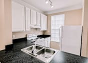 Thumbnail 4 of 39 - a kitchen with white cabinets and black counter tops and a sink