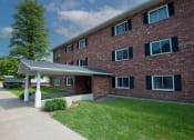 Thumbnail 21 of 28 - a large brick apartment building with a covered walkway in front of it