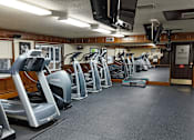 Thumbnail 9 of 26 - A gym with treadmills and elliptical machines.