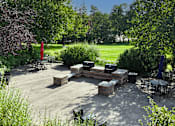 Thumbnail 15 of 26 - A backyard patio with a fire pit and seating area.