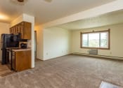 Thumbnail 3 of 28 - an empty living room with a kitchen and a large window