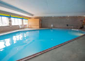 Thumbnail 8 of 28 - a large indoor swimming pool with brick walls and a blue ceiling